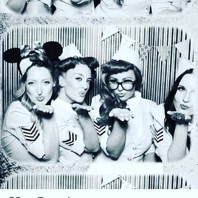 Hostesses in vintage sailor-style uniforms at a photo booth